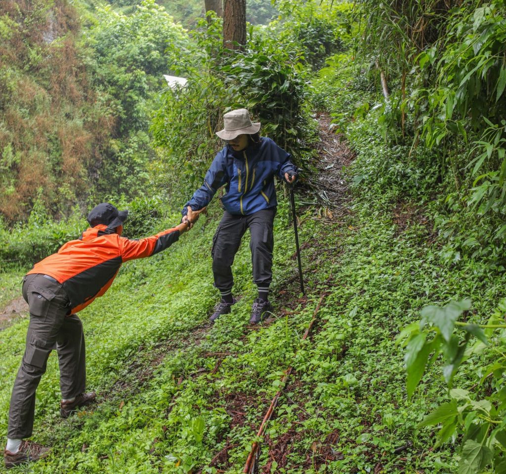 Two Hikers Supporting Each Other On Challenging Trail